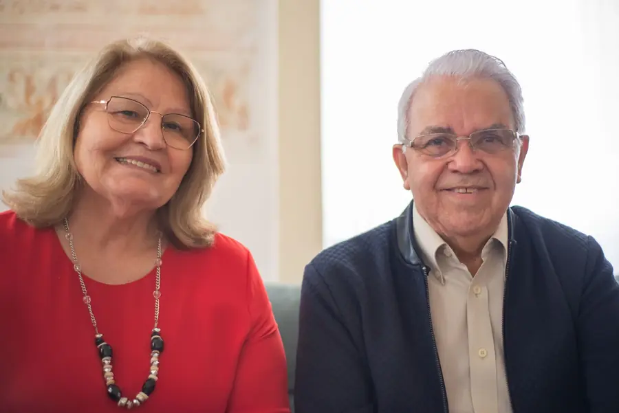 An older Latino couple smiling side by side